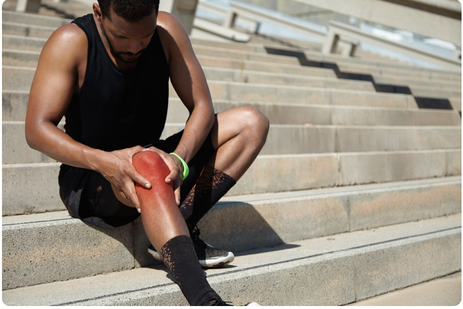 계단에서 무릎 앞쪽 통증을 느끼는 젊은 남성